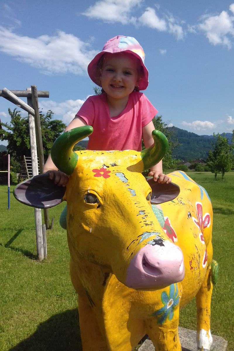 Kind reitet auf einer Kuhfigur